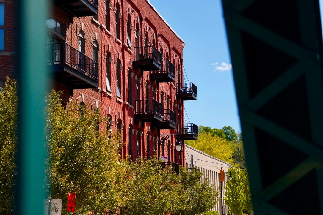 Red brick apartments with black balconies on a sunny day