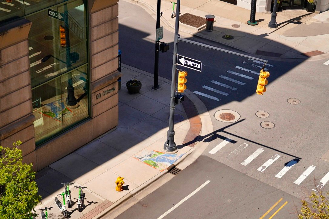 A downtown intersection from above, with a one-way sign and traffic lights